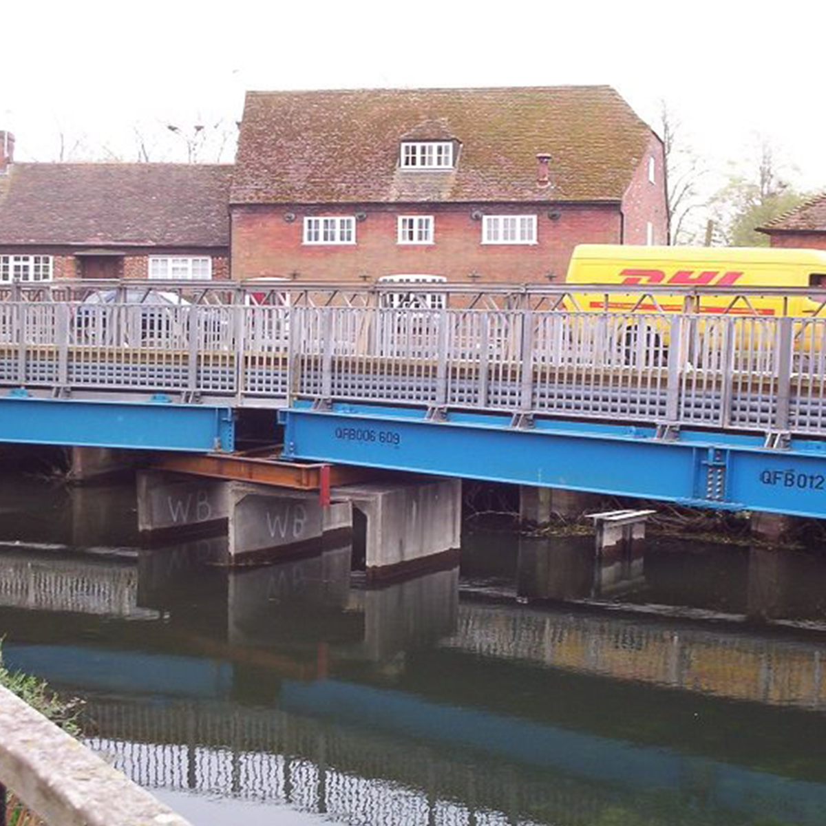 MH International pedestrian beam bridge on site over river by residential area